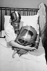 A mother and baby, both in gas masks, during WWII.