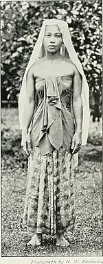 A kain lepas with a broad sash (kain kemban) dressed over a Terengganuan style of flowered sarong with kain kelubung.